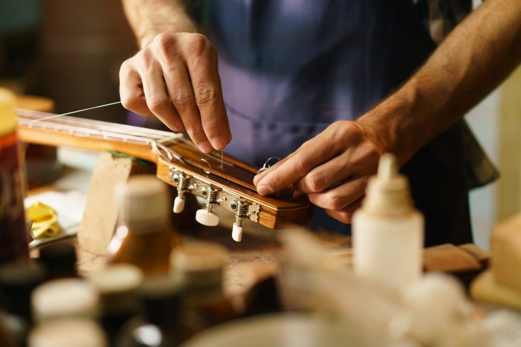 Person Fixing Stringed Instrument Replacing Guitar string