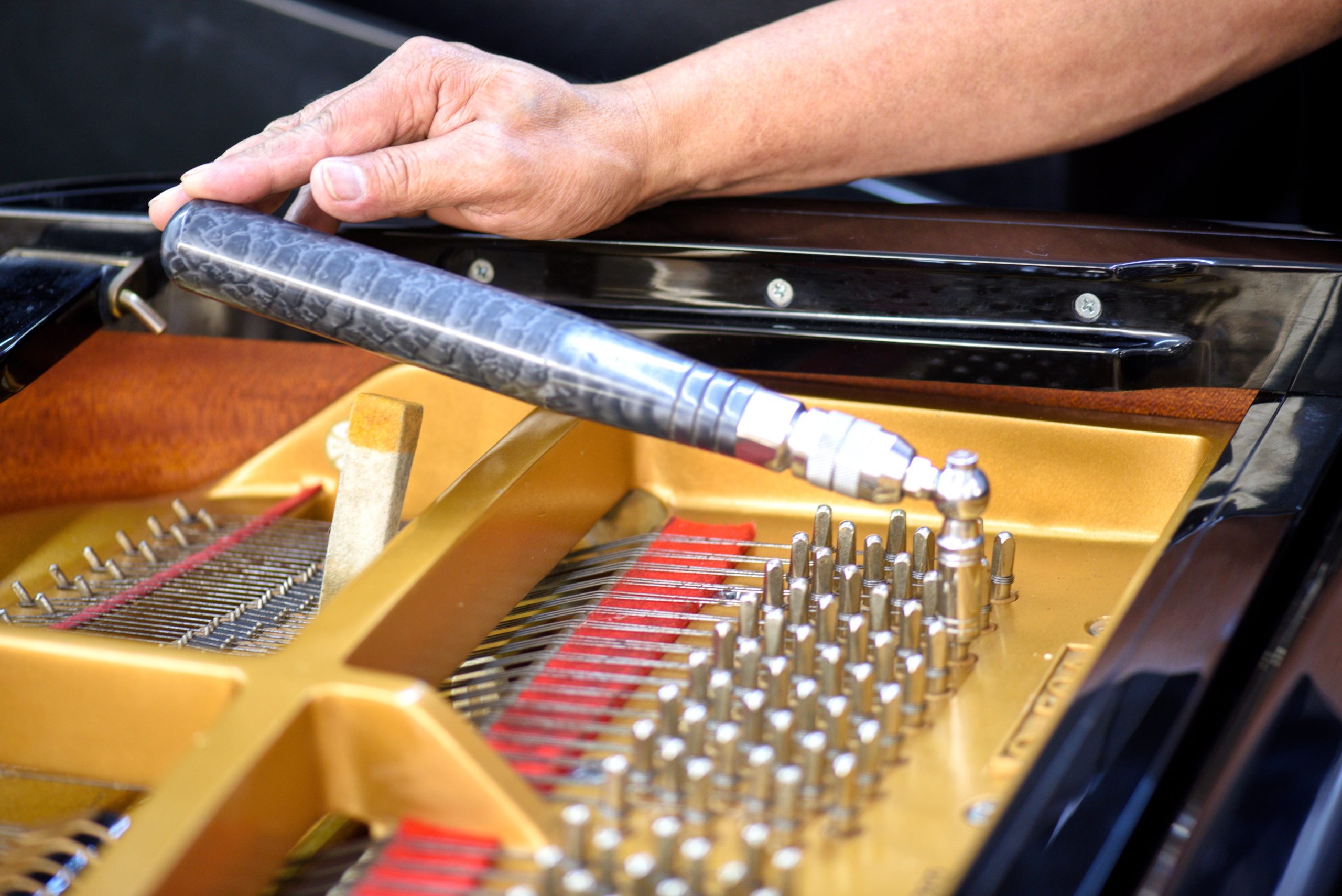 a piano technician tuning piano