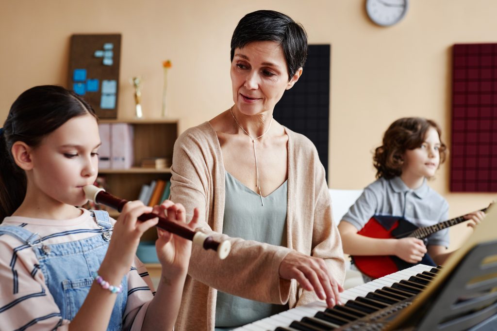 Teacher playing musical instruments with student